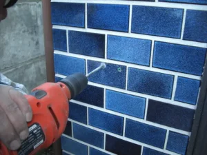 振動ドリルで壁に下穴を空けている様子