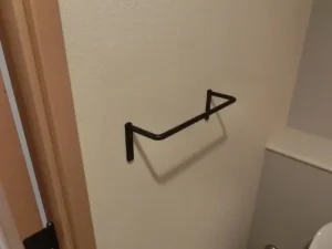 トイレに取付けたシンプルなデザインの黒いタオル掛け