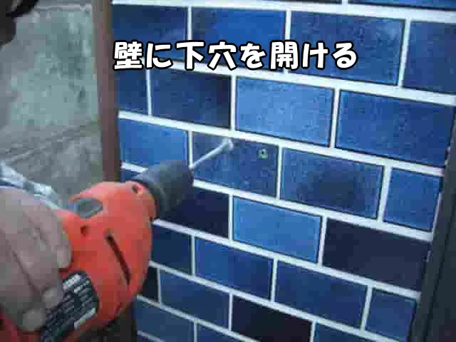 振動ドリルで壁に下穴を空けている様子
